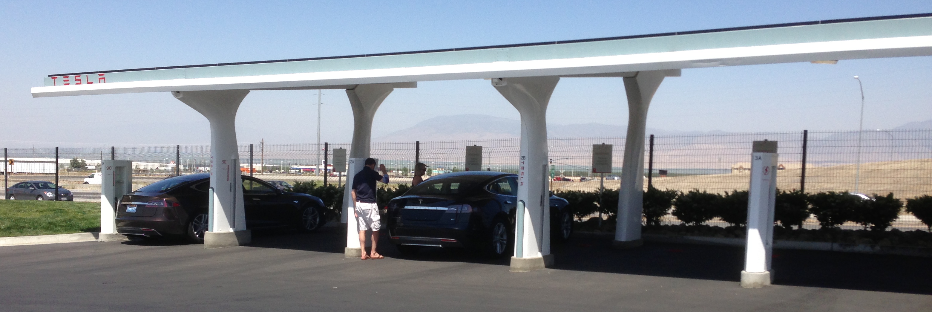 Tesla_charging_station_with_solar_collector_trimmed.jpeg